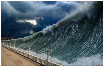 Massive ocean wave crashes near seaside promenade under dark stormy sky before sunset.