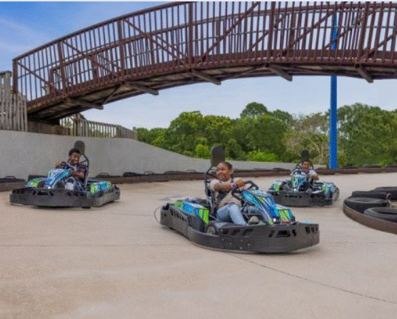 a group of people riding go-karts under a bridge