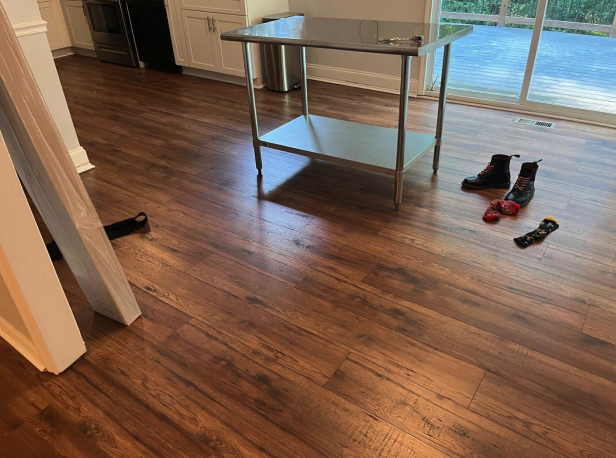 Wide-plank laminate flooring installed over a leveled subfloor with a new stair transition by Concept Flooring near Atlanta