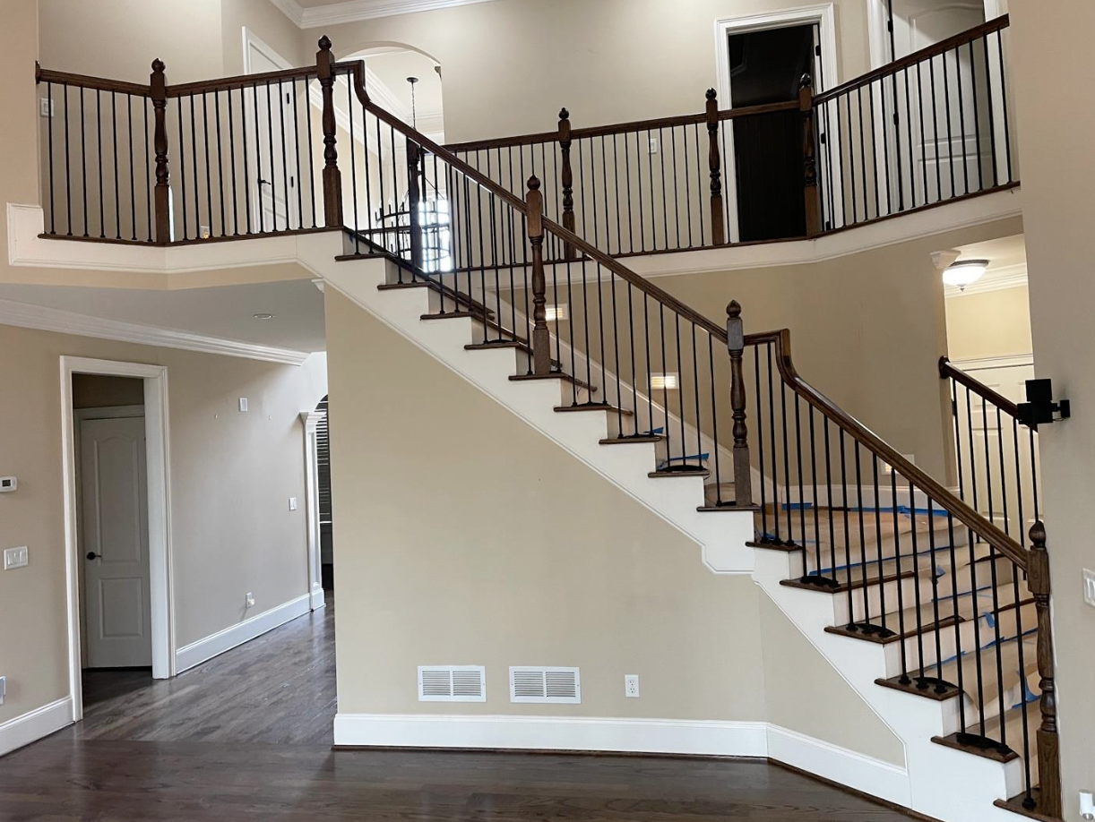 1,400 sq ft hardwood refinished dark brown satin with new wrought iron balusters in Milton, GA by Concept Flooring