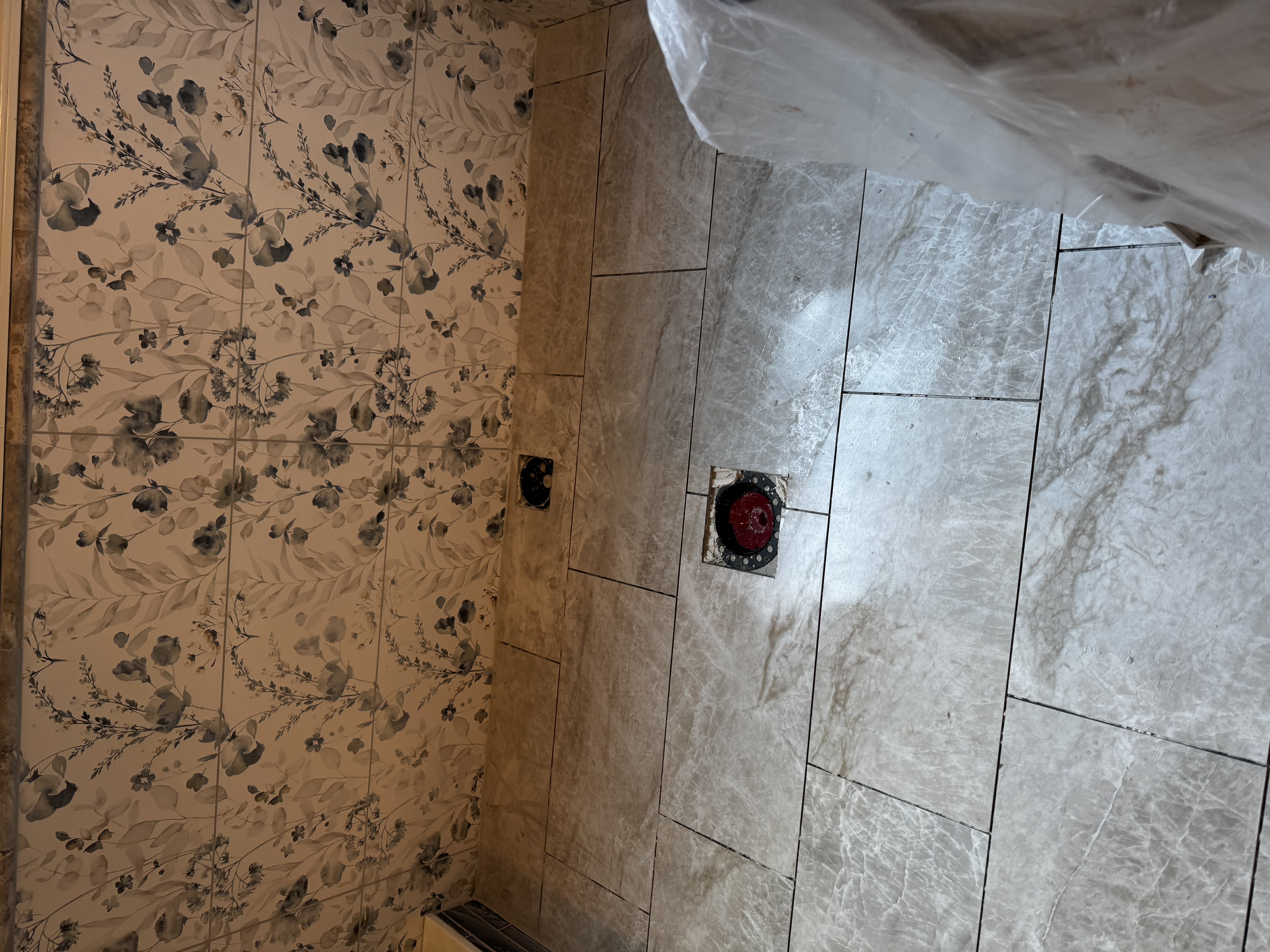 Completed bathroom renovation with new flooring, double vanity, and freestanding bathtub