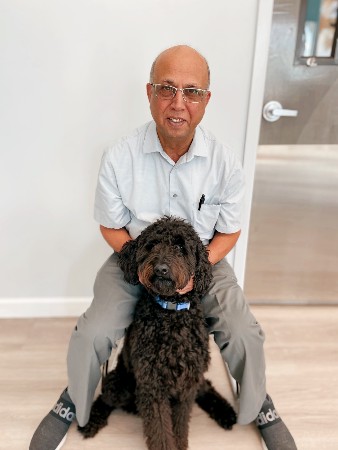 Dr. Malik sitting with a dog