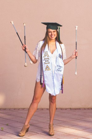 Shelly C in a graduation cap with batons