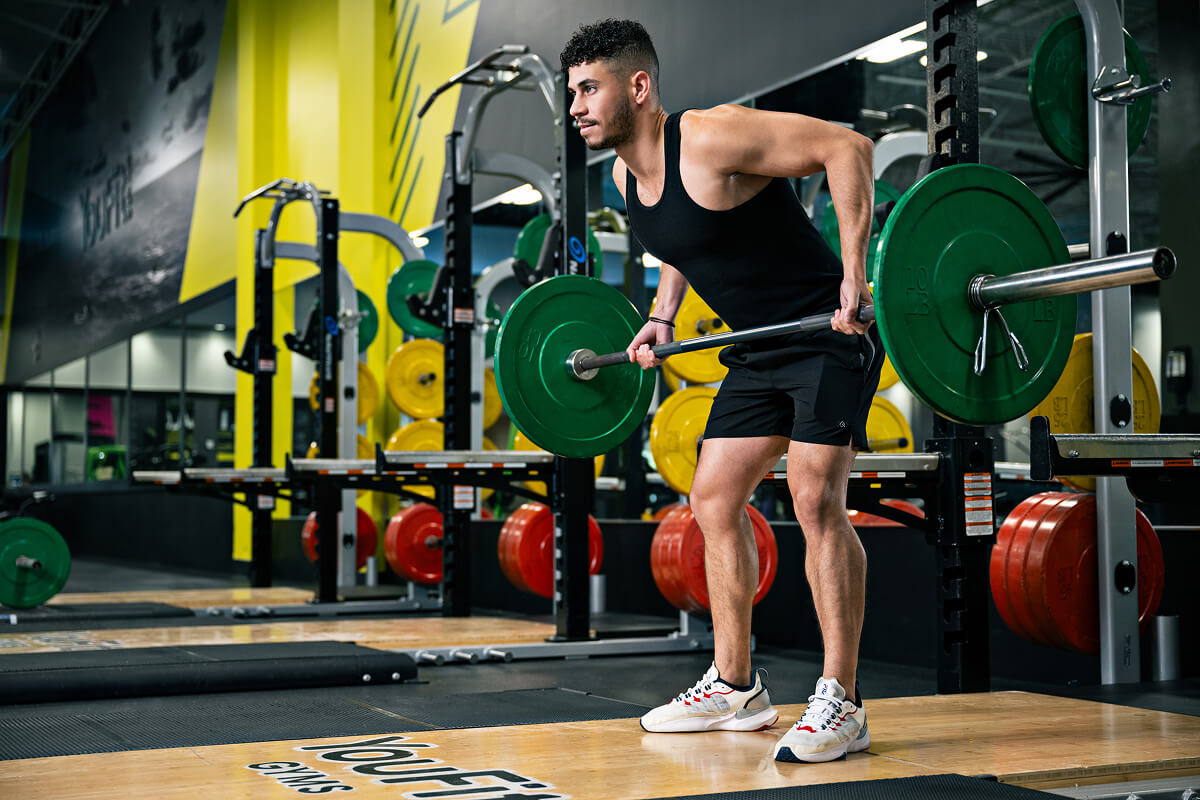 Lifter performing a bent-over barbell row in a gym