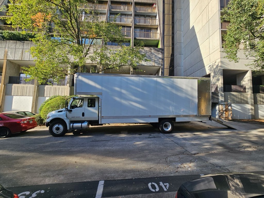 Midtown Moving box truck parked outside a high-rise apartment building