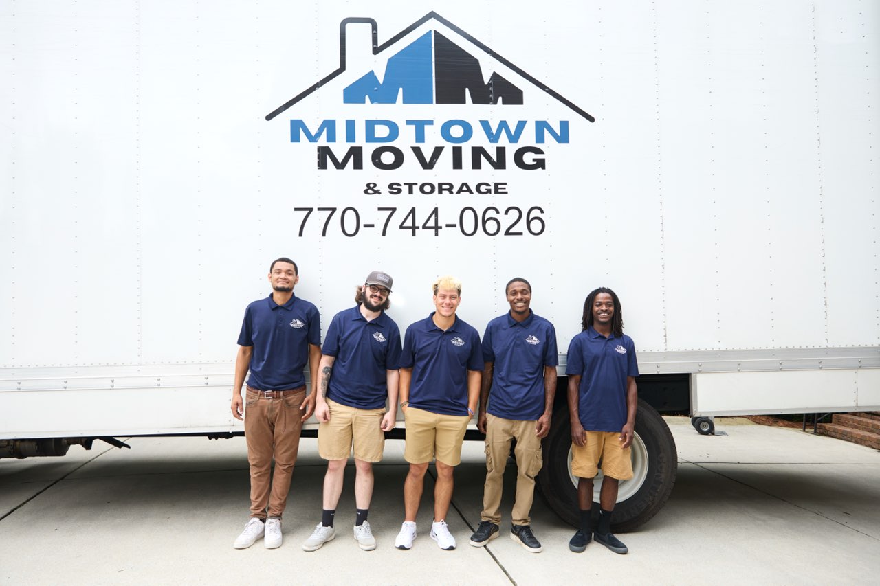 The Midtown Moving crew in uniform standing in front of a Midtown truck