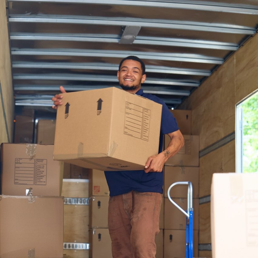 Midtown mover carrying a box out of the truck during an apartment move