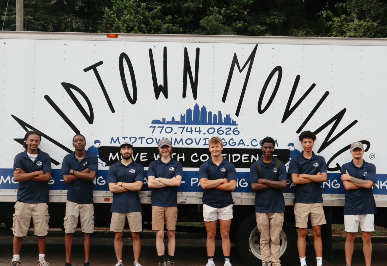 The Midtown Moving crew in uniform standing in front of a Midtown truck