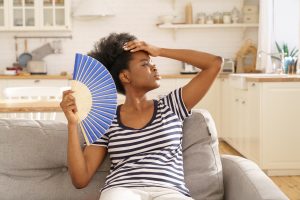 African woman fanning herself cause heat