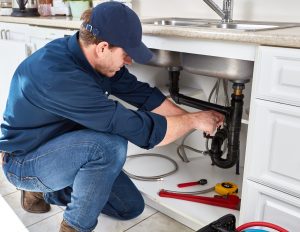 plumber working under kitchen sink