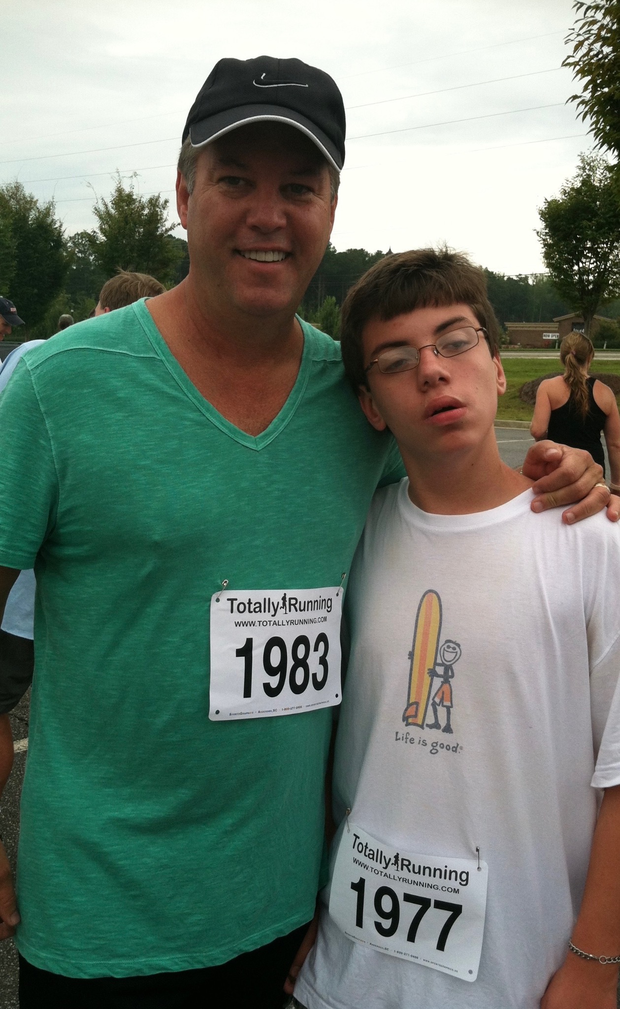A father and son posing together after a race