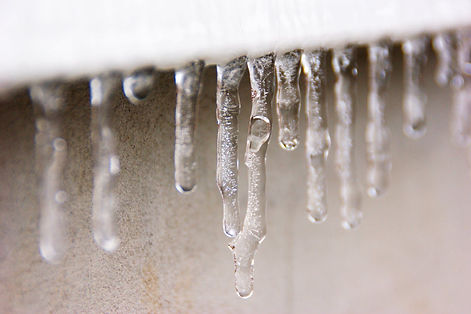 Small icicles hanging from the edge of a roof.