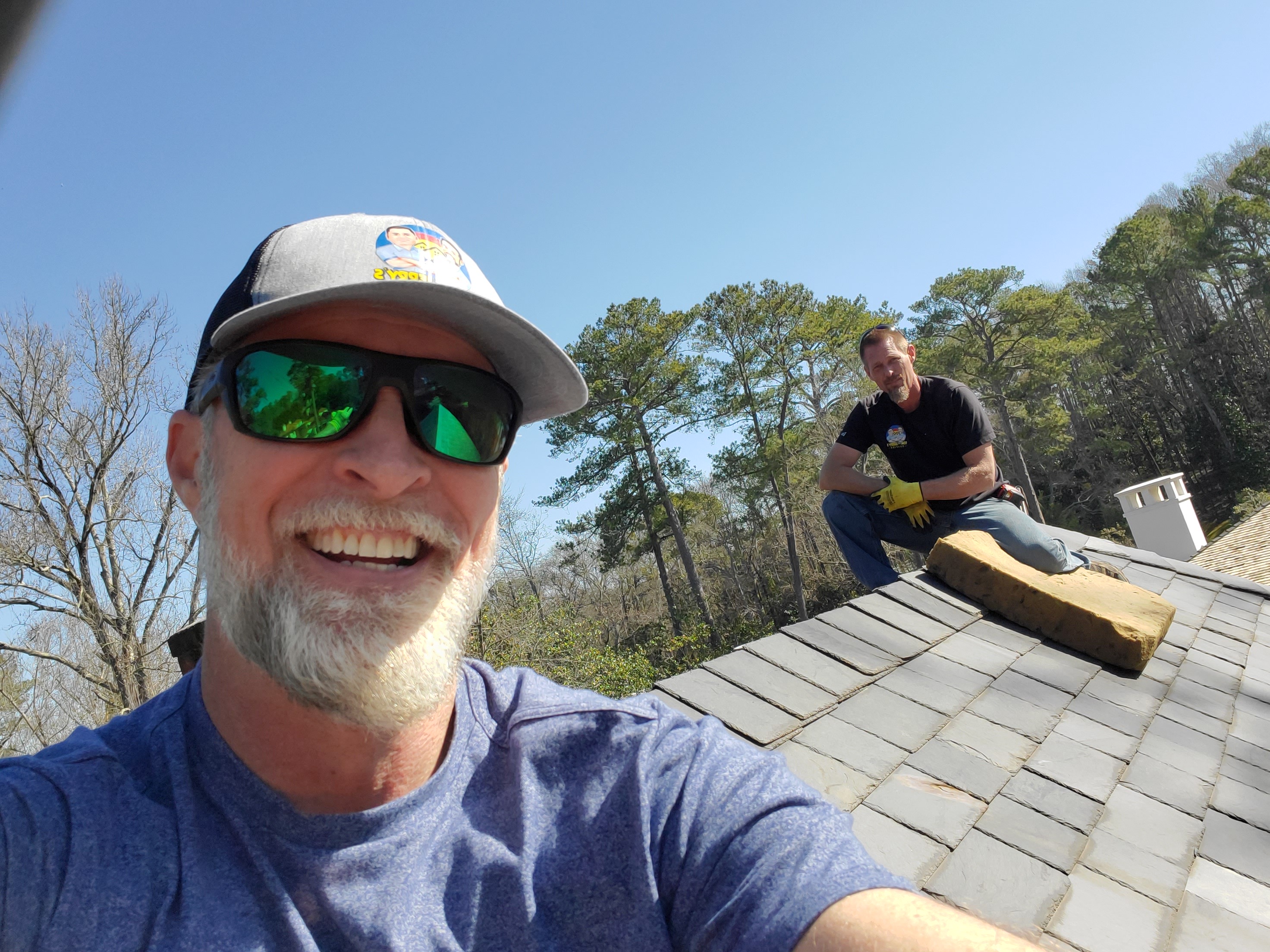 Tom and John Roberts standing on a rooftop, inspecting a roofing project. Tom is on the left, and John is on the right, ensuring top-quality craftsmanship.
