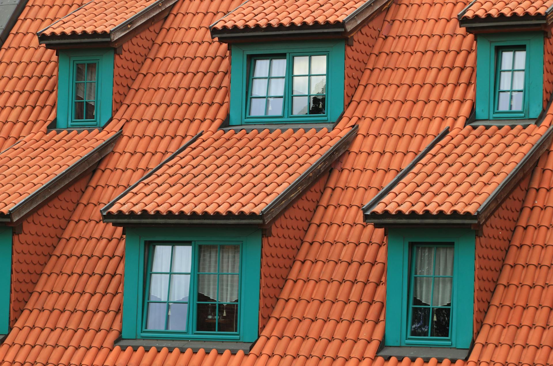 Terracotta roof shingles on a house painted deep green.