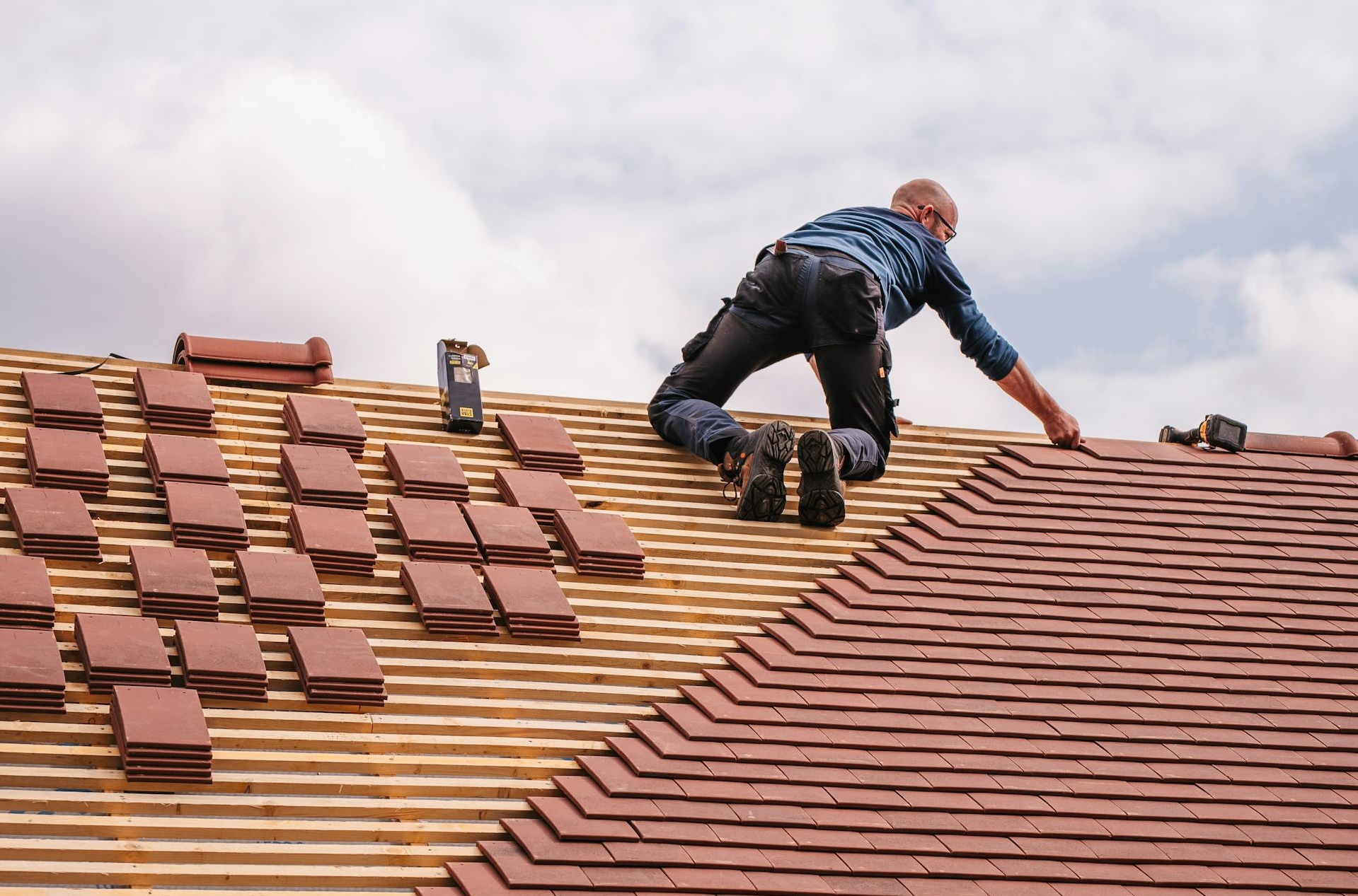 Roofing professional installs new shingles on a roof.
